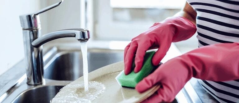 person handwashing plate because there's no dishwasher in apartment