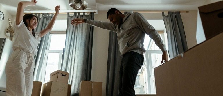 People dancing happily in an apartment with all of their must-haves