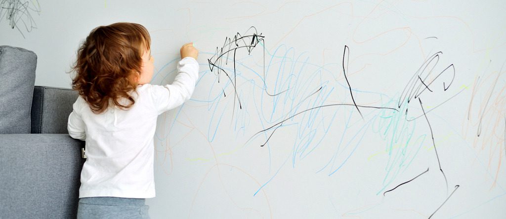 Child drawing on wall