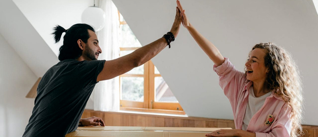 Couple high-fiving over boxes