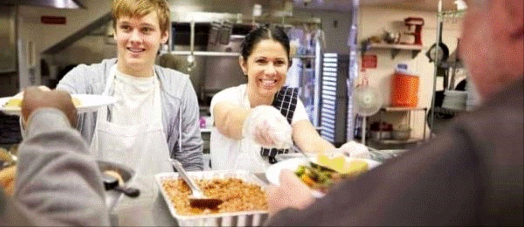 two people feeding the unhoused
