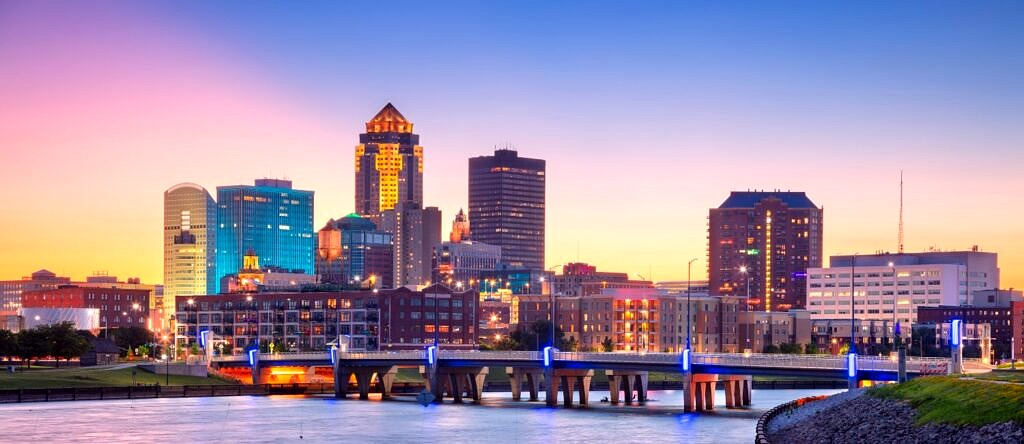A view of the Des Moines, IA skyline as night falls on the city from across the river.